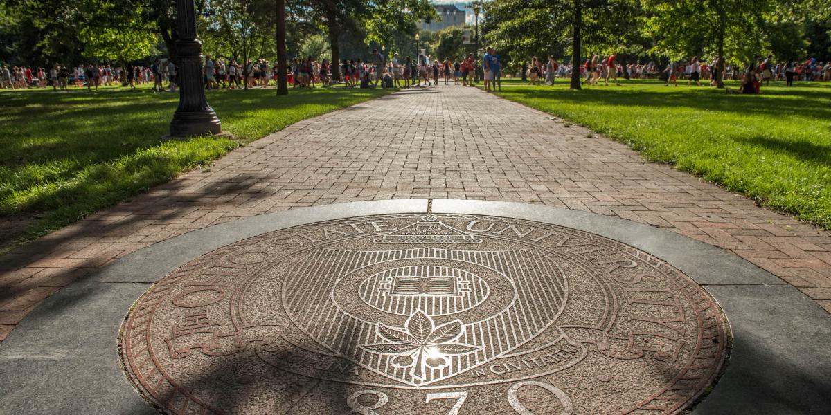 Picture of the seal of The Ohio State University on a brick walkway in the Oval.