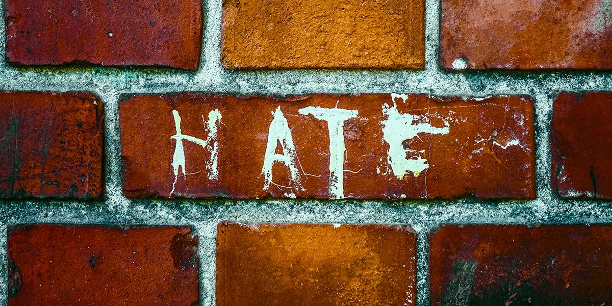 "Hate" painted on a brick wall
